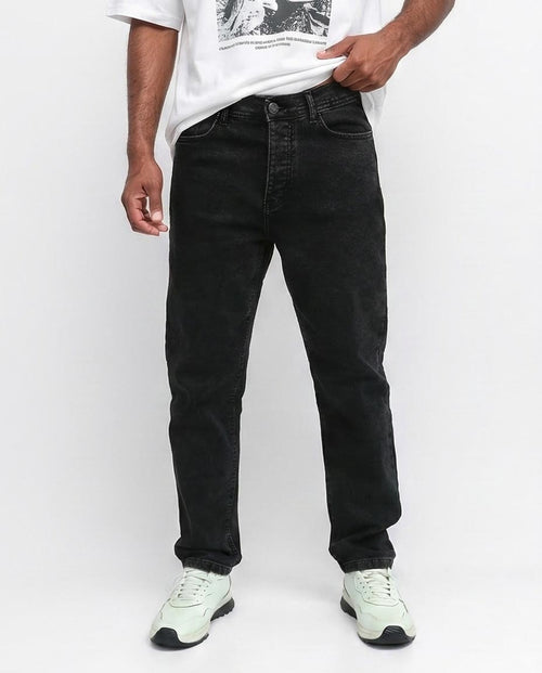 Person wearing black jeans and a white t-shirt on a white background