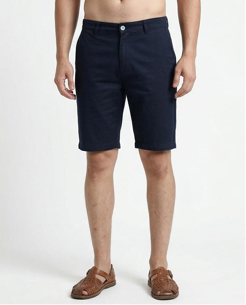 Navy blue shorts worn by a person on a white background