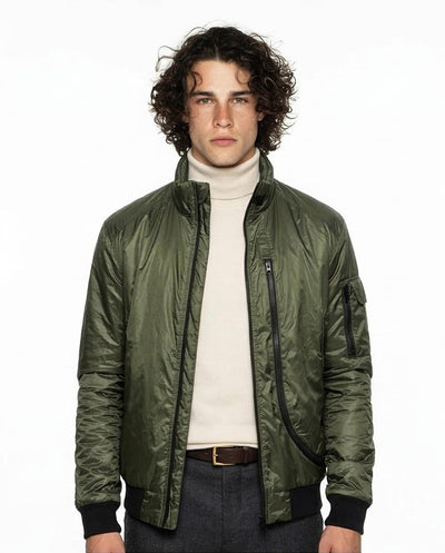 Man wearing a green bomber jacket over a white turtleneck on a white background