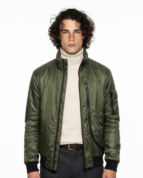 Man wearing a green bomber jacket over a white turtleneck on a white background