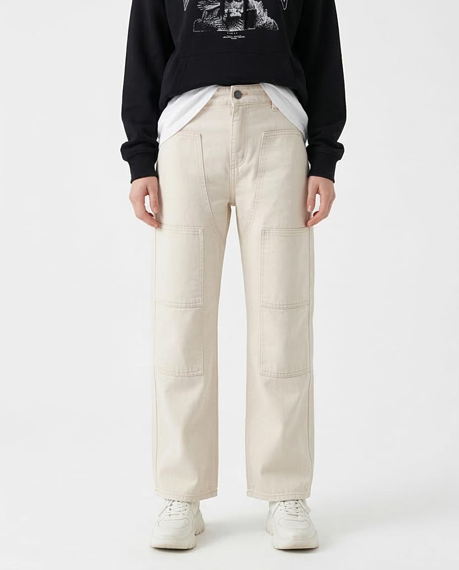 Woman wearing beige pants and a black sweatshirt with a graphic design on a white background