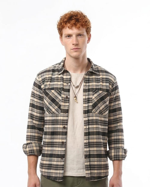 Man wearing a plaid shirt over a white t-shirt on a white background