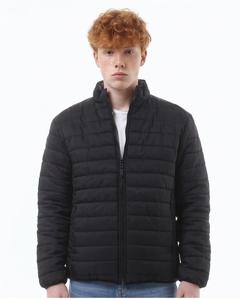 Person wearing a black puffer jacket on a white background