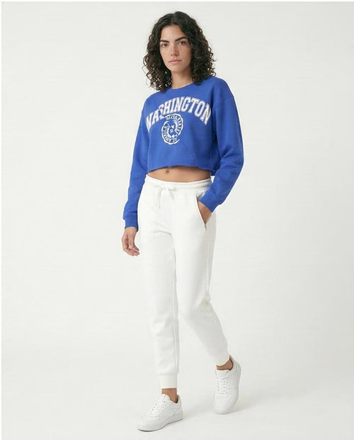 Woman wearing a blue 'Washington' sweatshirt and white pants on a white background