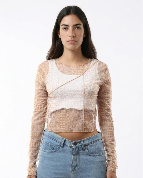 Woman wearing a sheer long-sleeve top with a white background