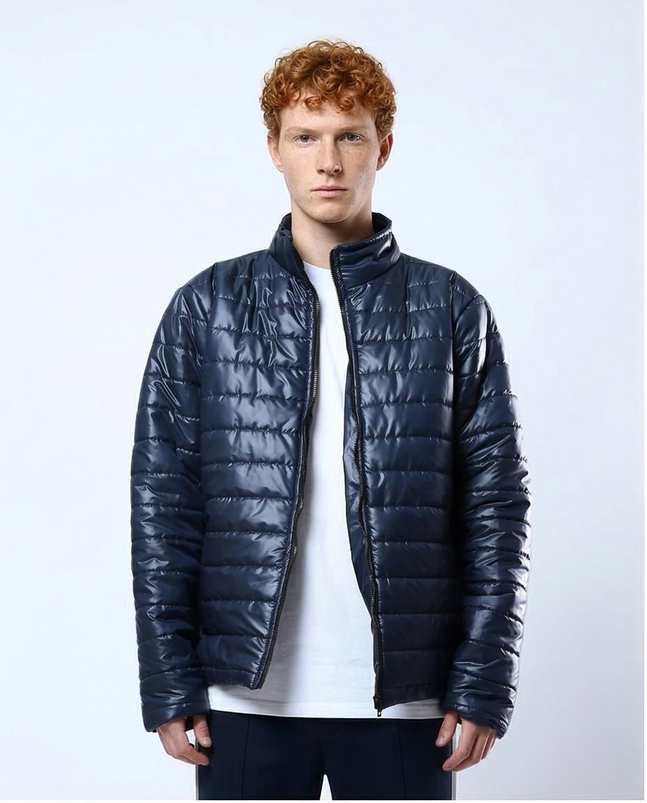 Man wearing a navy blue puffer jacket on a light gray background