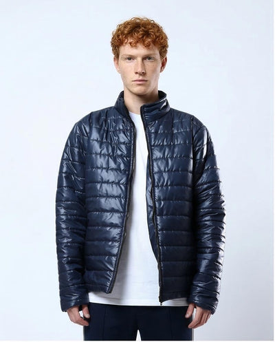Man wearing a navy blue puffer jacket on a light gray background