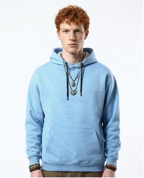 Man wearing a light blue hoodie with a plain background