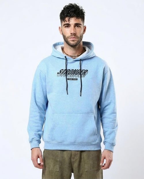 Man wearing a light blue hoodie with text on a white background