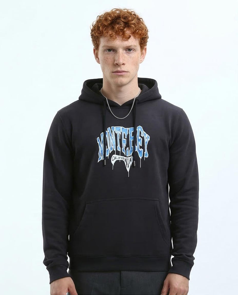 Person wearing a black hoodie with a brand logo on a light gray background