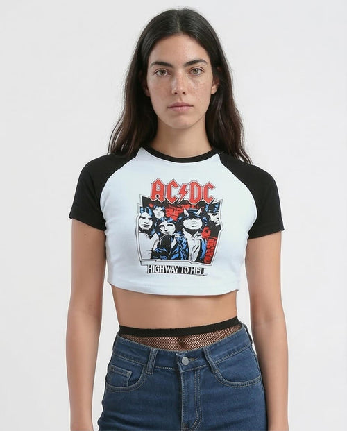 Person wearing a black and white AC/DC-themed crop top with jeans on a plain background