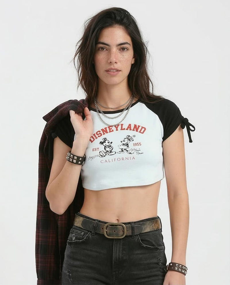 Woman wearing a crop top with Disneyland branding on a white background