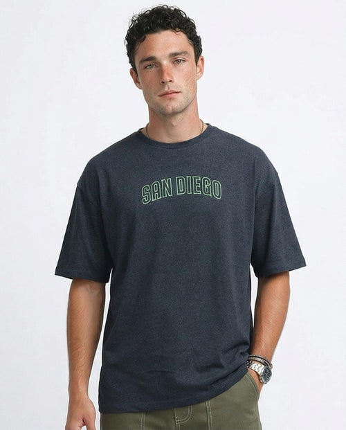 Man wearing a dark blue t-shirt with 'San Diego' printed on it against a light gray background