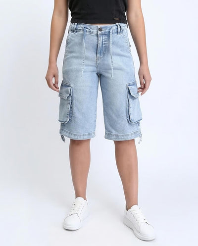 Person wearing light blue denim cargo shorts on a white background