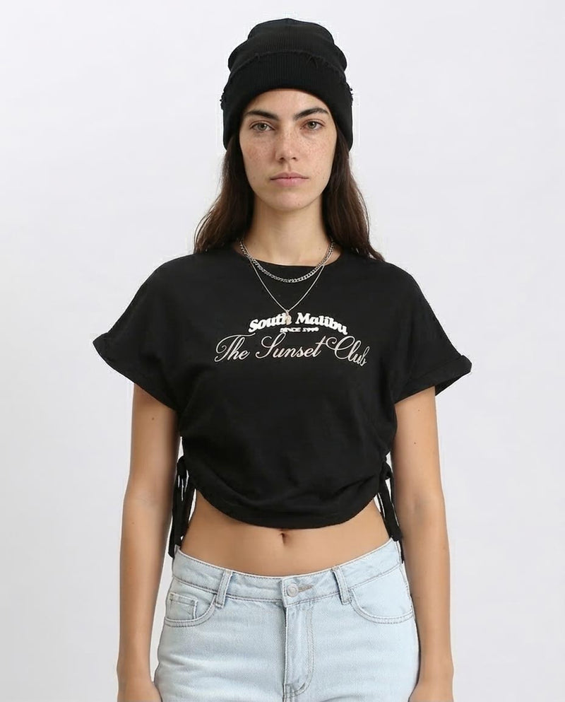 Person wearing a black t-shirt with 'South Malibu The Sunset Club' text on a white background