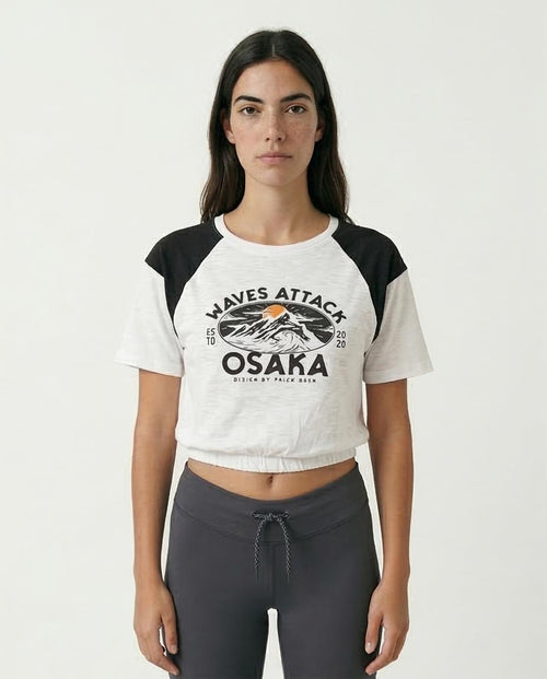 Woman wearing a white and black baseball shirt with 'Waves Attack Osaka' print on a white background