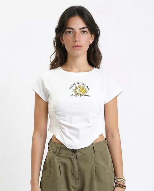 Woman wearing a white t-shirt with a graphic design on a plain background