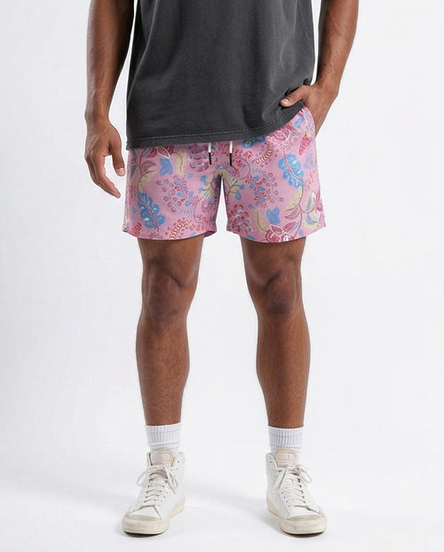 Person wearing pink floral shorts on a white background