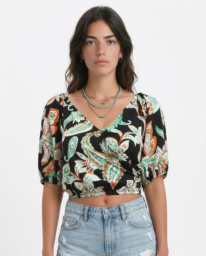 Woman wearing a patterned top with a plain background