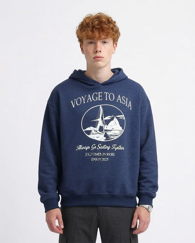 Person wearing a navy blue hoodie with 'Voyage to Asia' print on a white background