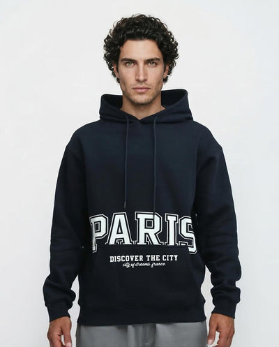 Man wearing a black hoodie with 'Paris Discover the City' text on a white background