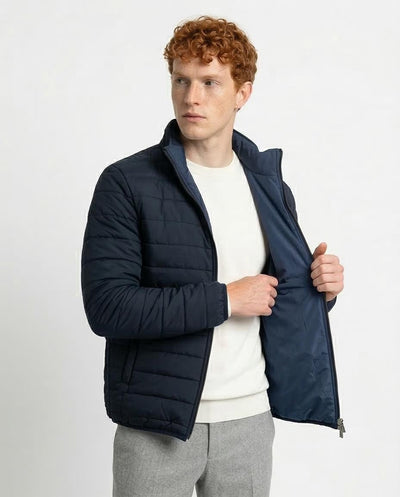 Man wearing a navy puffer jacket on a white background