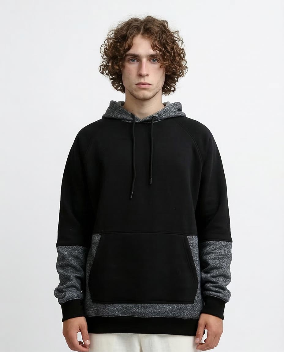 Person wearing a black and gray hoodie on a white background