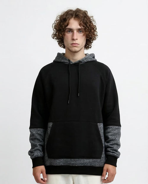 Person wearing a black and gray hoodie on a white background