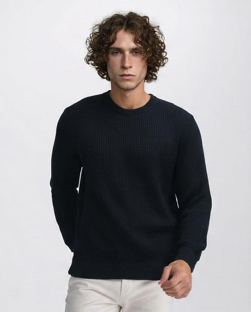 Man wearing a dark blue sweater against a white background