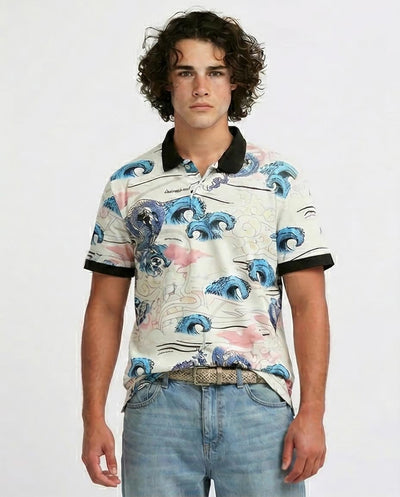 Man wearing a patterned shirt with blue wave design on a plain background