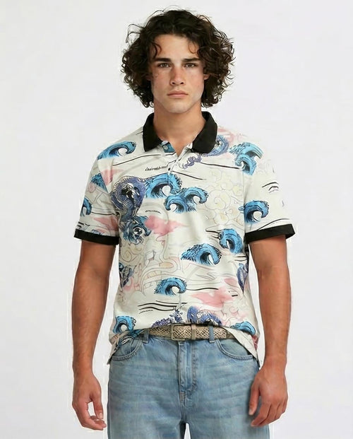 Man wearing a patterned shirt with blue wave design on a plain background