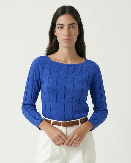 Woman wearing a blue sweater with a white background