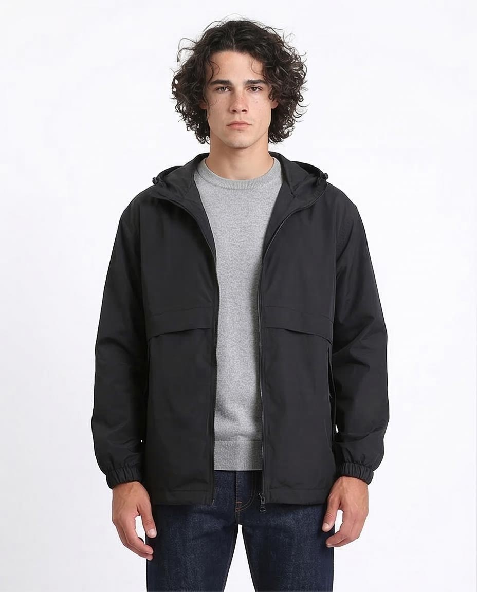 Man wearing a black jacket over a gray shirt on a white background