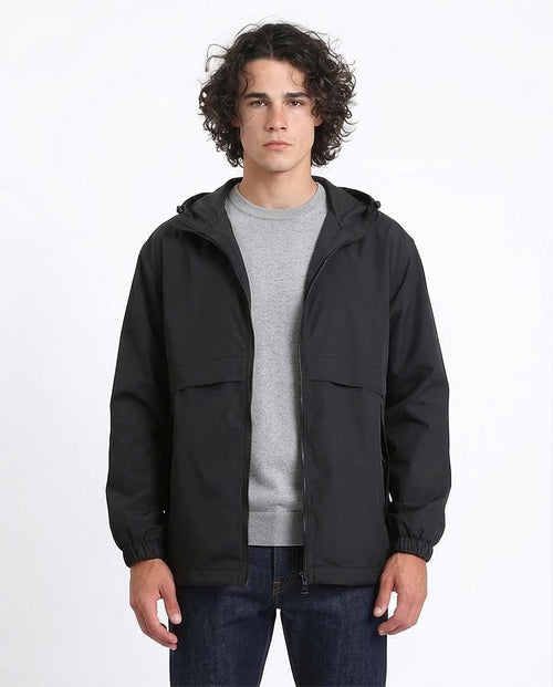 Man wearing a black jacket over a gray shirt on a white background