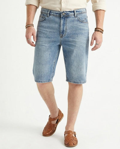 man wearing light blue denim shorts on a white background
