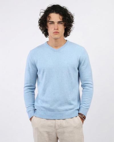 Man wearing a light blue sweater against a white background