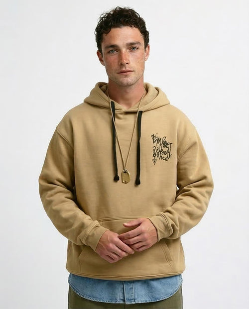 Man wearing a beige hoodie with a logo on a white background