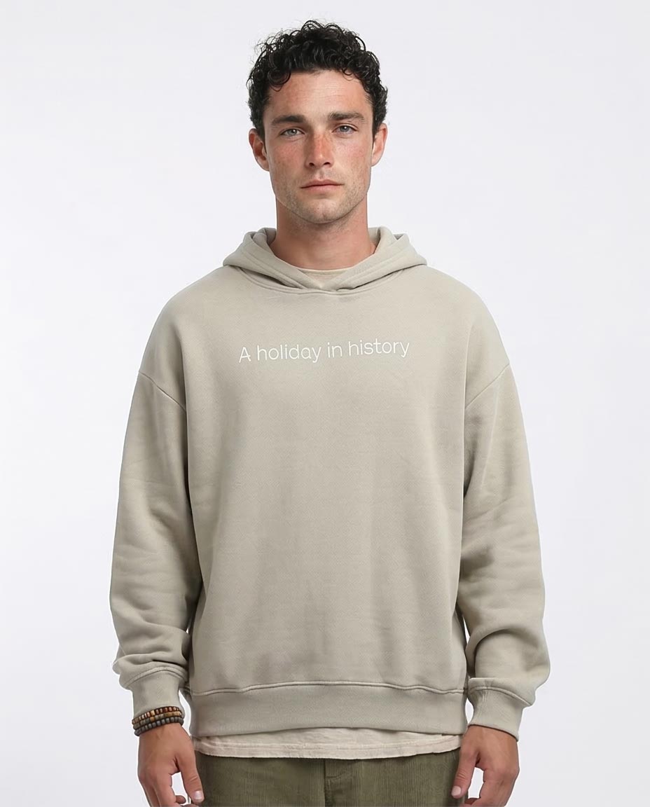 Man wearing a beige hoodie with text on a white background