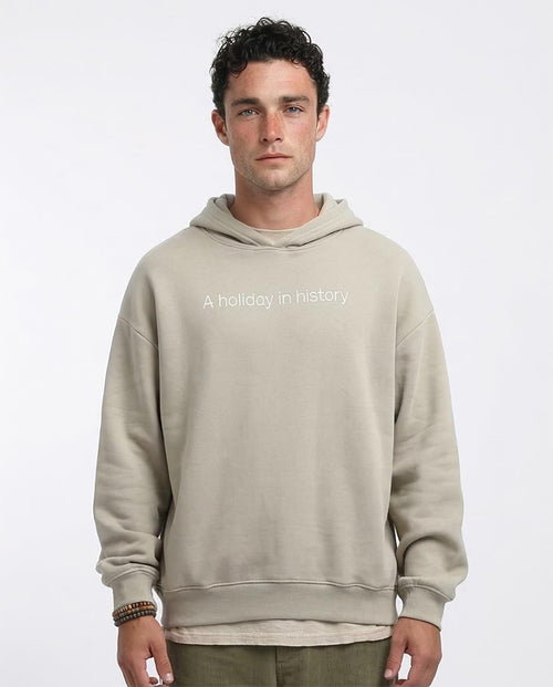 Man wearing a beige hoodie with text on a white background
