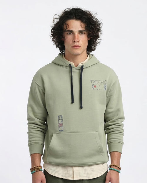 Man wearing a green hoodie with text and graphics on a white background