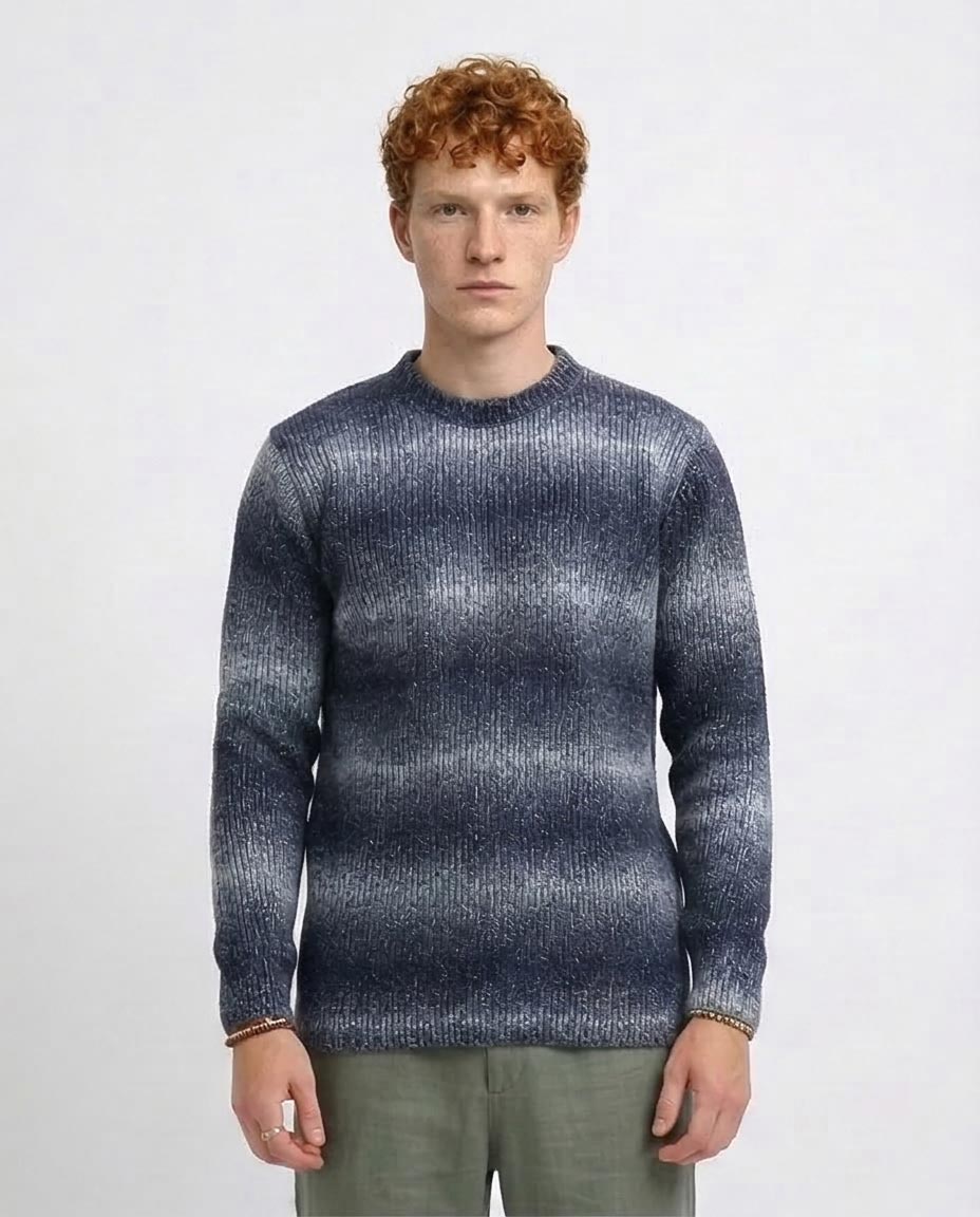 Man wearing a patterned sweater on a plain background