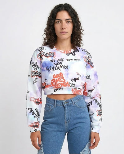 Person wearing a white sweatshirt with colorful text and graphics, paired with blue jeans on a plain background