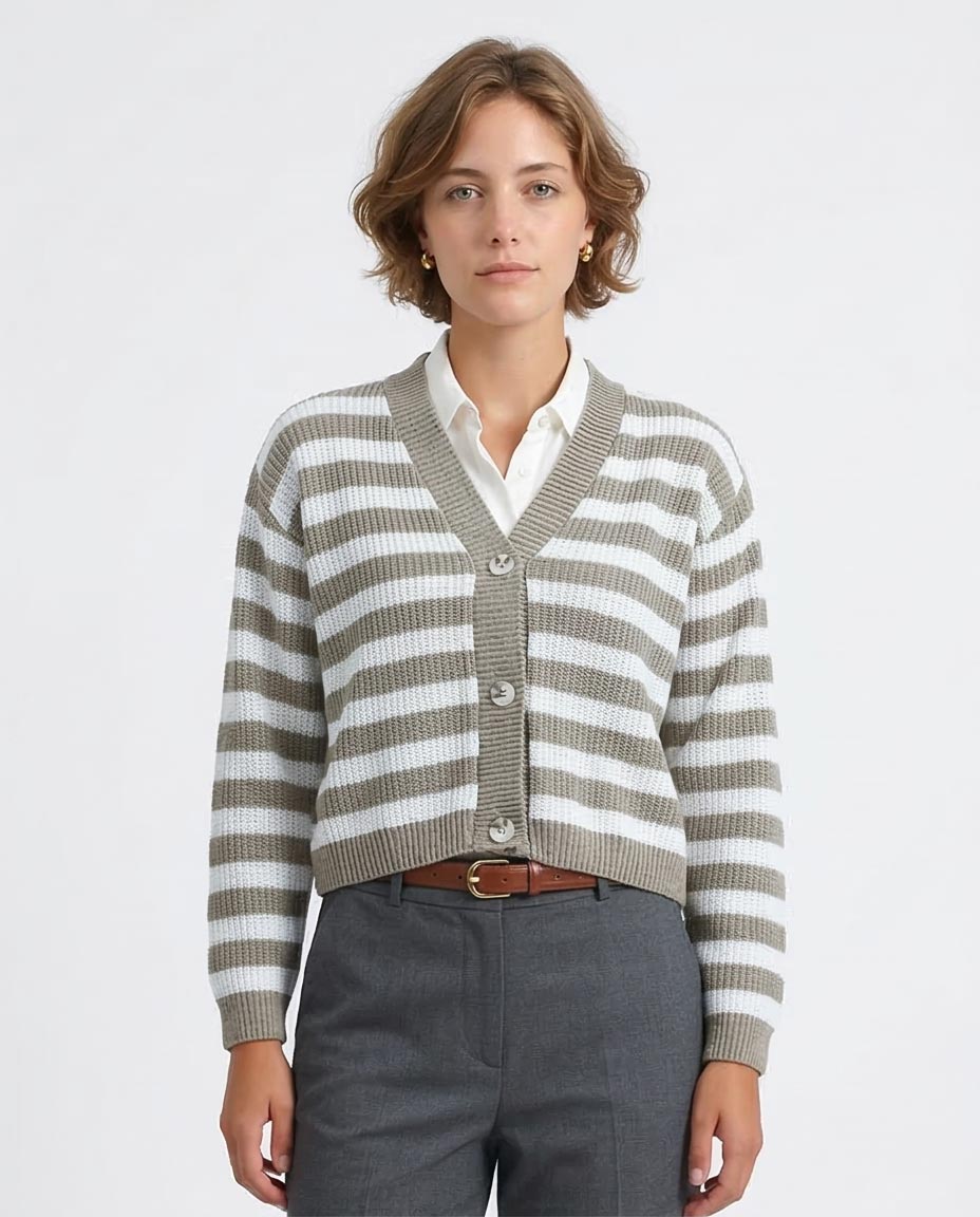 Woman wearing a striped cardigan over a white shirt with gray pants on a light gray background