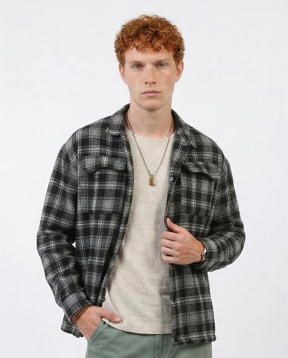 Man wearing a plaid shirt over a t-shirt on a white background