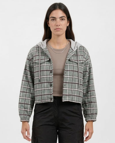 Person wearing a plaid jacket over a beige shirt on a white background