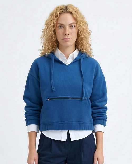 Woman wearing a blue hoodie with a zipper on a white background