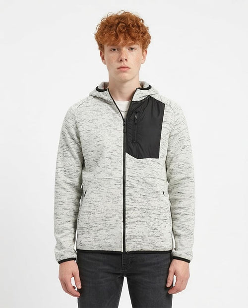 Person wearing a gray and black jacket on a white background