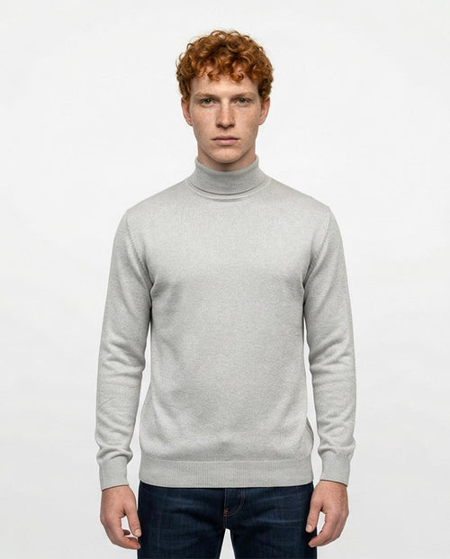 Man wearing a light gray turtleneck sweater on a white background