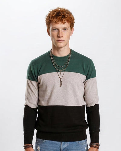 Man wearing a color-blocked sweater with green, beige, and black sections on a white background.