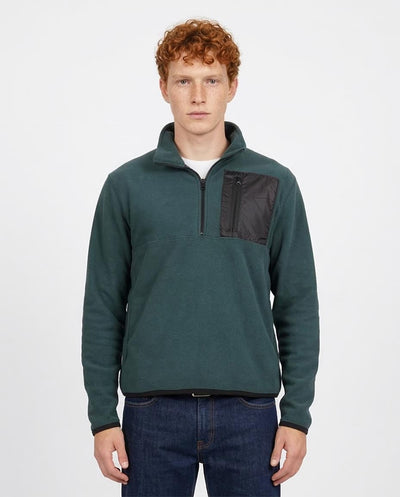 Man wearing a green pullover with a black pocket on a white background